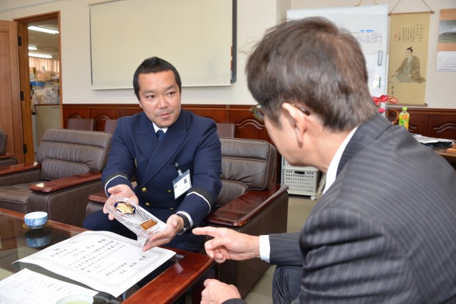 最優秀賞の記念の盾を松木市長に披露する平山消防士長（左）＝下田市役所