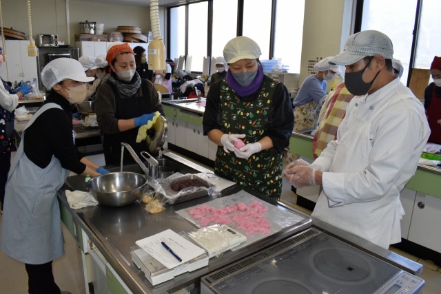 瀬戸さん（右）から菓子作りを学ぶ職員たち＝松崎町の環境改善センター