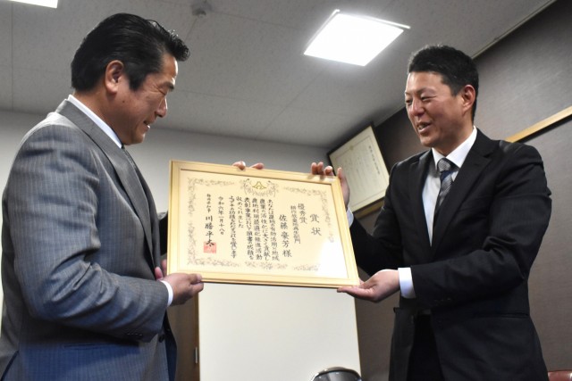 賞状を手に、岡部町長（左）に優秀賞受賞を報告する佐藤さん＝南伊豆町役場