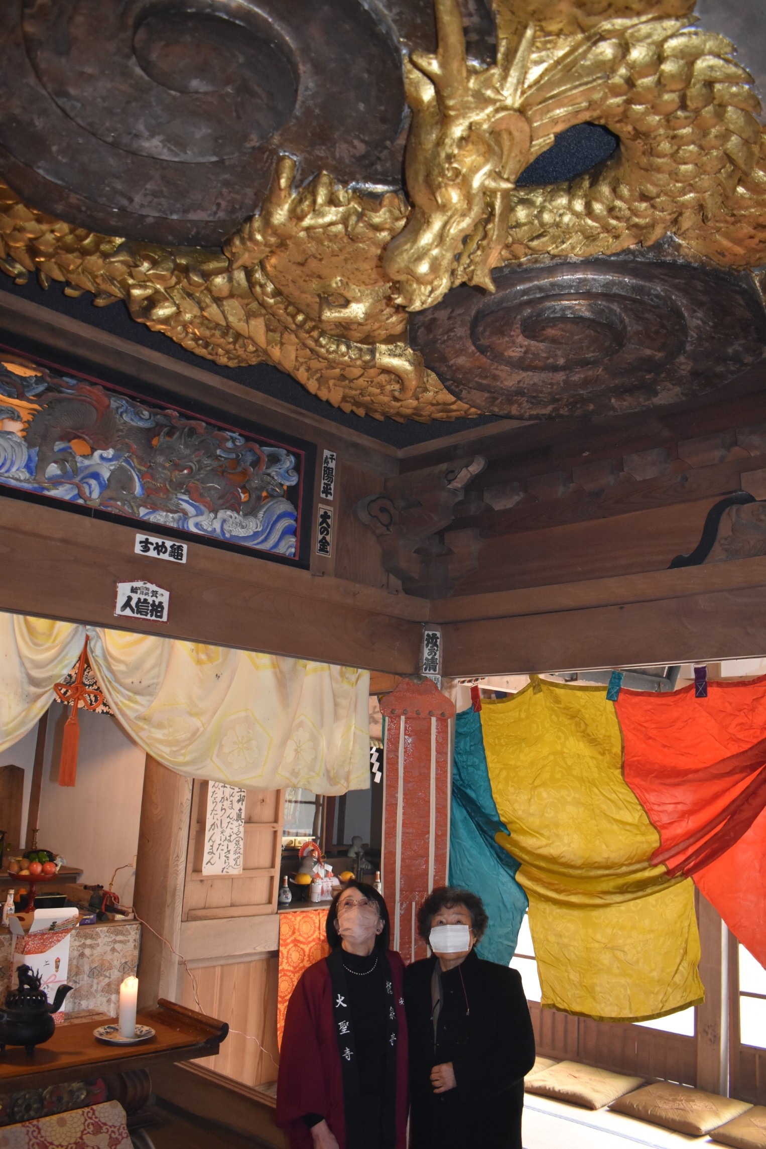 天井に設置された竜の彫刻を眺める町民＝西伊豆町安良里の大聖寺