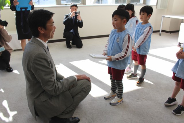 斉藤市長（左）からクレヨンを受け取る園児＝熱海市役所