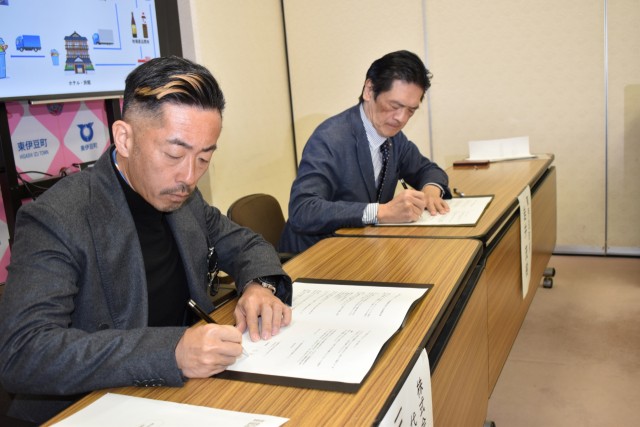 協定書に署名する三根社長（左）と岩井町長＝東伊豆町役場
