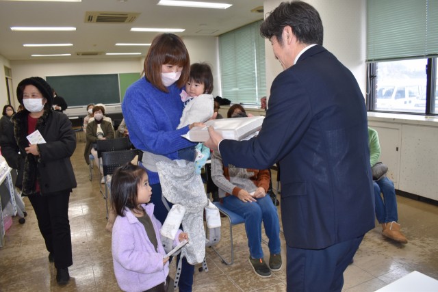 鈴木副町長（右）から賞品を受け取る当選者＝東伊豆町役場