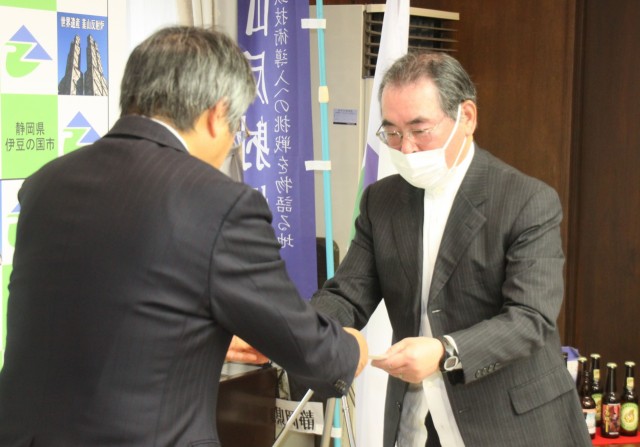 山下市長（左）に答申書を手渡す小嶋会長＝伊豆の国市役所