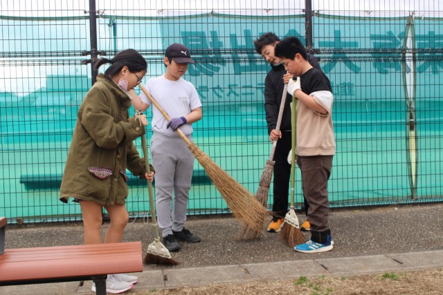 ほうきを使い清掃する長岡北小６年生たち＝伊豆の国市南江間の江間公園