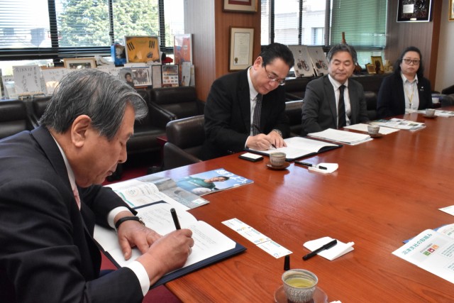 協定書に署名する豊岡市長（左）と松尾支社長（左から２人目）＝三島市役所