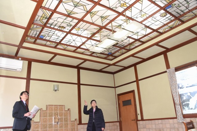 天井にアールデコ調ステンドグラスがふんだんに使われたサンルームを紹介する小沢教授（右）＝伊豆の国市奈古谷の旧新津家別邸主屋