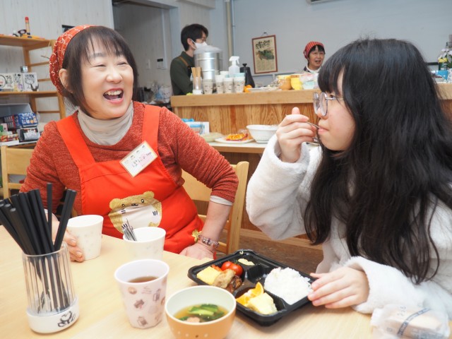 子どもに食事を振る舞い、会話をする石橋代表（左）＝熱海市清水町