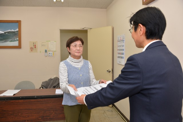 芹沢副地区長に義援金を手渡す渡辺部長（左）＝下田市役所
