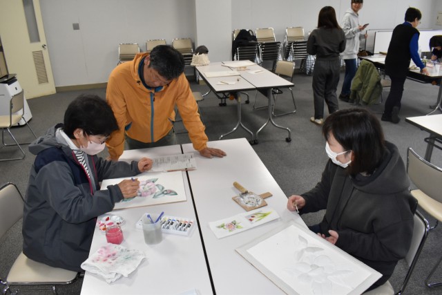 高橋さん（左から２人目）から鏝絵の指導を受ける参加者＝松崎町の環境改善センター