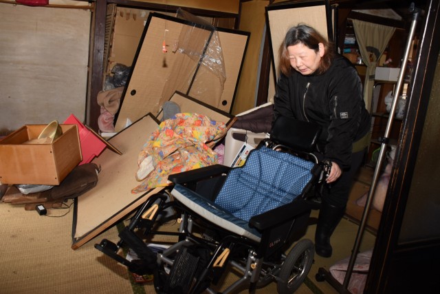 地震が起きたときのままの部屋で母清香さんの車椅子に触れ、思いを語る紀子さん＝石川県能登町