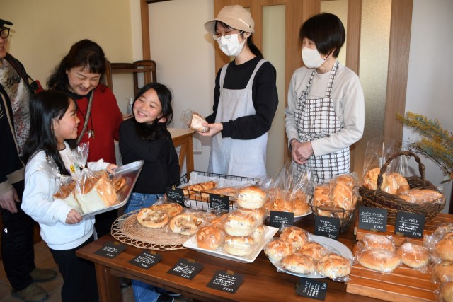 店主の中田さん（右から２人目）が作るこだわりの無添加パンが人気の「パン・ド・ローフ」。右は母美智子さん＝伊東市八幡野