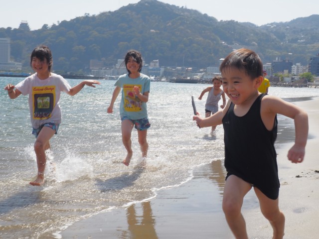 波打ち際を駆け回って遊ぶ子ども＝熱海市東海岸町の熱海サンビーチ