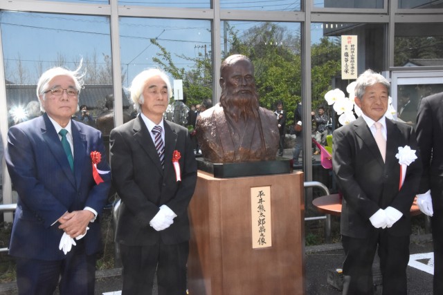 平井熊太郎の胸像を披露する塩谷・中伊豆山葵組合長（右）ら＝伊豆市原保の「イズワサビジターセンター」
