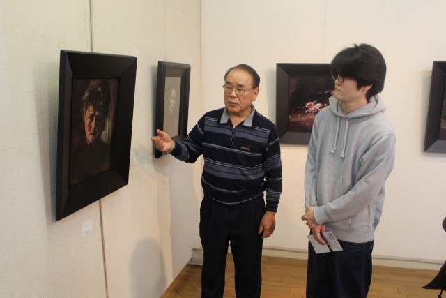 藤崎さんの絵について解説する大庭館長（左）＝三島市大場のパサディナ美術館