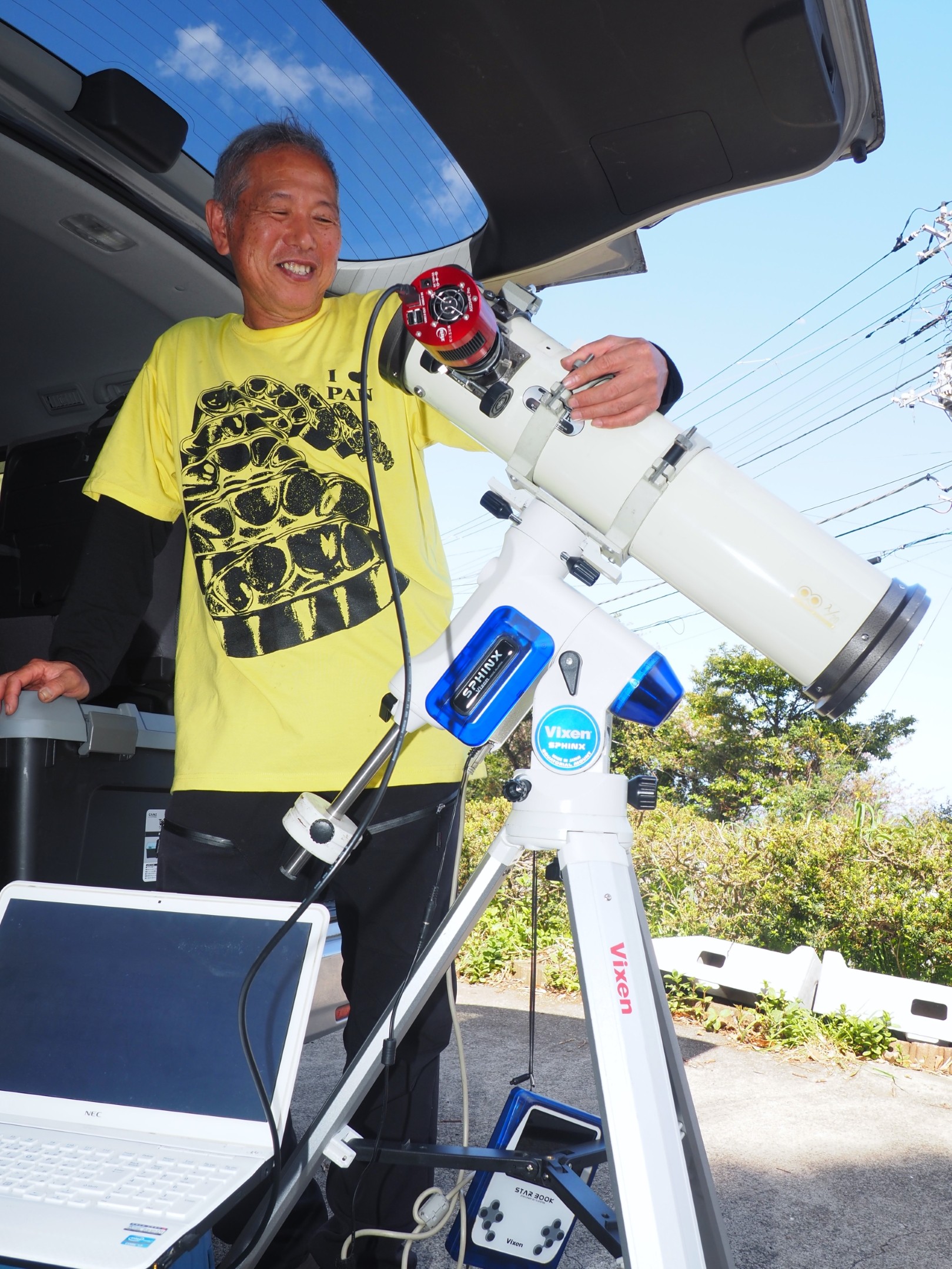 望遠鏡を手に語る長沢さん＝熱海市上多賀